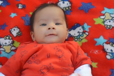 Portrait of cute baby girl lying on bed