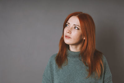 Portrait of young woman against black background