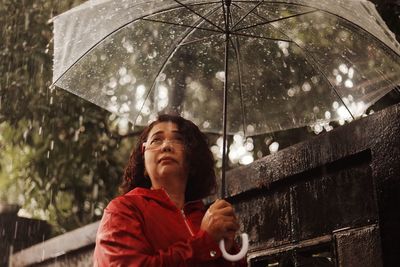 Portrait of woman with wet umbrella during monsoon