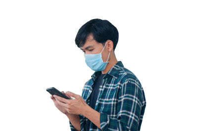 Young man using smart phone against white background