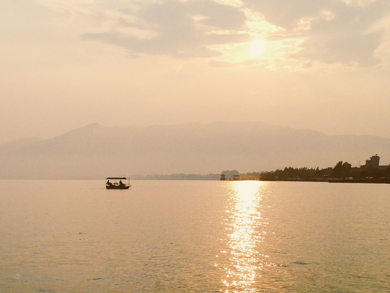 water, beauty in nature, nautical vessel, sunset, reflection, nature, scenics, waterfront, tranquility, mode of transport, sky, transportation, tranquil scene, outdoors, lake, no people, mountain, day