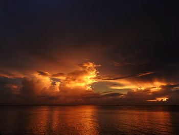 Scenic view of sea against dramatic sky during sunset