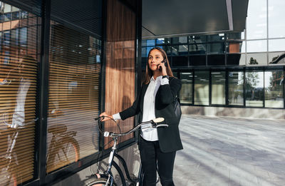 Side view of young woman standing in city