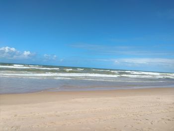 Scenic view of beach against blue sky