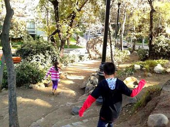 Rear view of boys walking on street