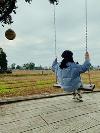 Rear view of woman walking on field