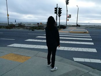 Rear view of woman walking on road