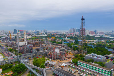 High angle view of city buildings against cloudy sky