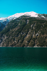 Scenic view of snowcapped mountains against blue sky