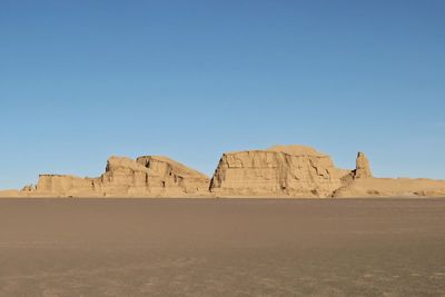 Rock formations in desert against clear blue sky