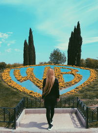 Rear view of woman standing against sky