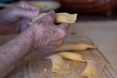 Close-up of hand holding bread on table