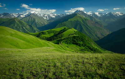 Beautiful green mountains with snowy peaks. scenic view of green mountains against sky