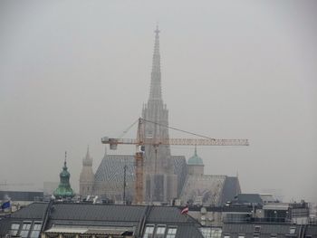 Tower amidst buildings in city against sky