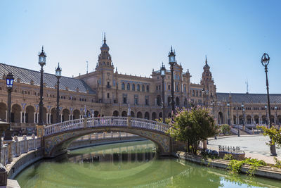 Arch bridge over river against buildings in city