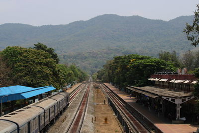 High angle view of railroad tracks amidst trees against mountains