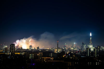 Illuminated cityscape against sky at night