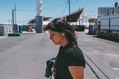 Side view of young woman on road in city