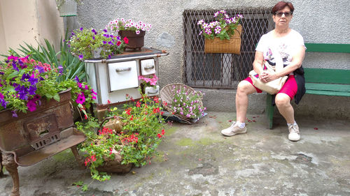 Portrait of woman standing by potted plants