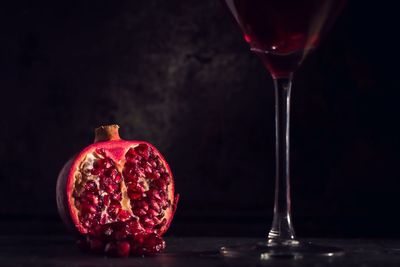 Close-up of red wine on table against black background