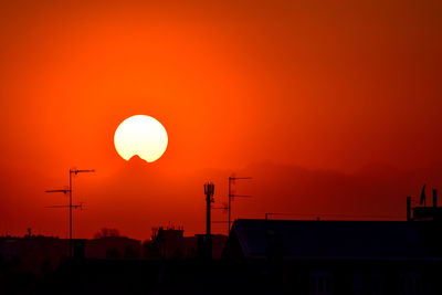 Silhouette of building against orange sky