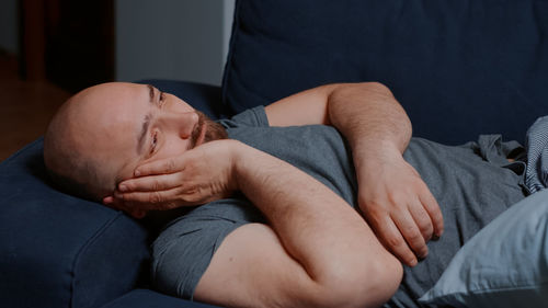 Low section of man relaxing on bed