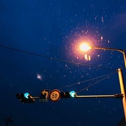 Low angle view of illuminated lights against blue sky