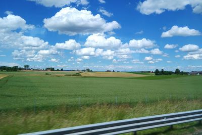 Scenic view of agricultural field against cloudy sky