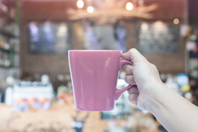 Close-up of woman holding drink in cafe
