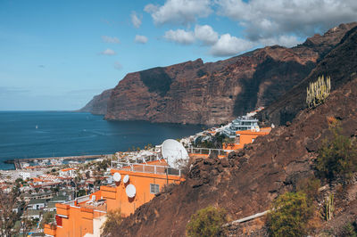 High angle view of townscape by sea against sky