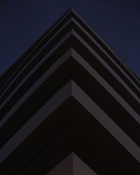 Low angle view of skyscraper against clear sky at night
