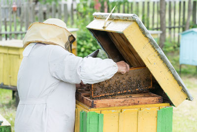 Beekeeper holding tray of honeycomb at park