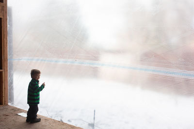 Little boy looking out at a construction site