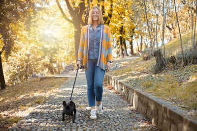 Portrait of man with dog standing in park