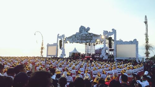 Group of people at music concert against sky