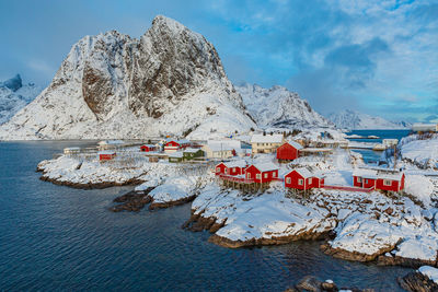 Scenic view of sea and snowcapped mountains against sky