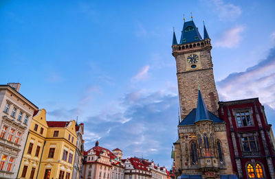 Low angle view of clock tower amidst buildings in city against sky