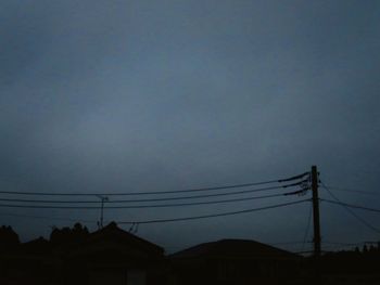 Low angle view of silhouette electricity pylon against sky