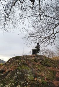 Man standing on rock against sky