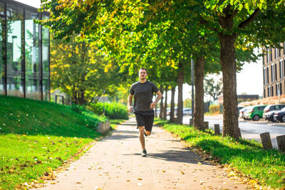 Full length of man running on footpath