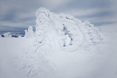 Snow covered land against sky