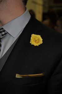 Midsection of man holding yellow flower