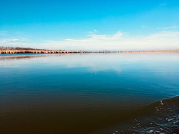 Scenic view of calm lake against blue sky