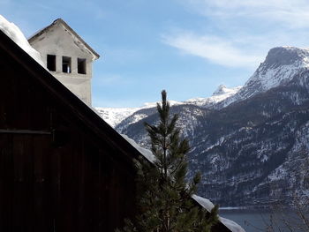 Built structure on snowcapped mountain against sky