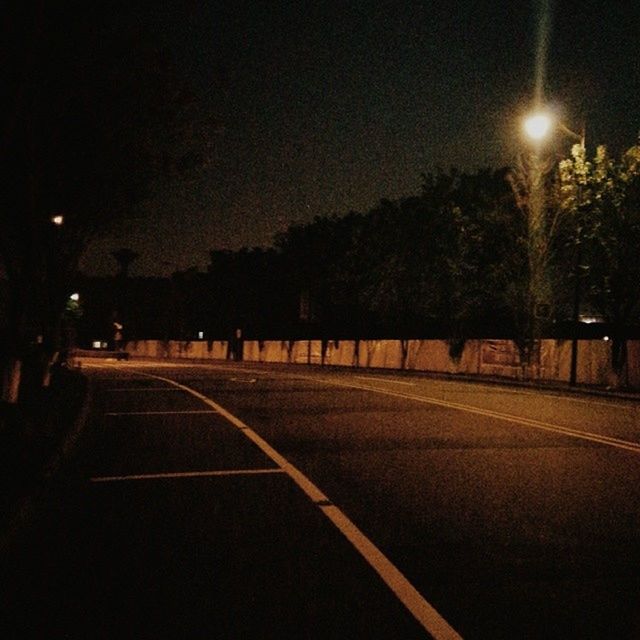 night, illuminated, street light, the way forward, road, transportation, tree, lighting equipment, road marking, street, diminishing perspective, sky, silhouette, vanishing point, empty road, dark, empty, outdoors, dusk, tranquility