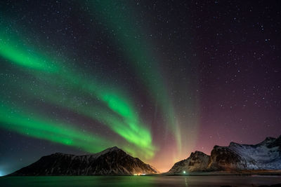 Scenic view of snowcapped mountains against sky at night