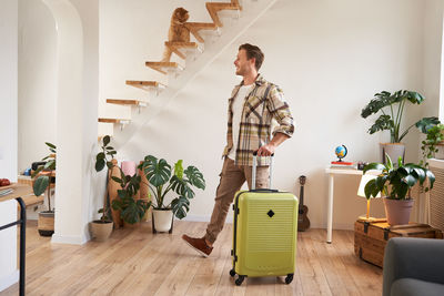 Rear view of woman standing in suitcase