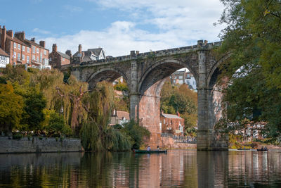 Arch bridge over river against sky