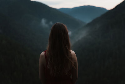 Cropped hand of woman against mountain