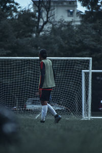 Rear view of boy playing soccer ball